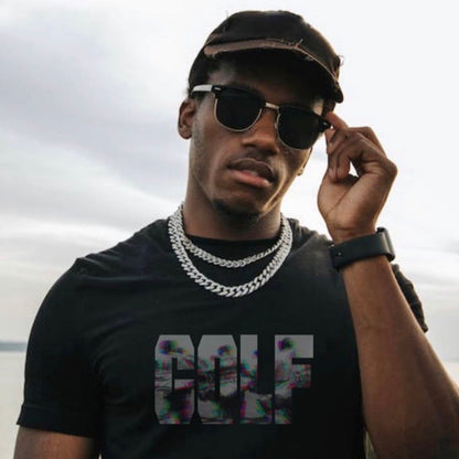 Man wearing the Caddy shirt in black with chains, sunglasses, and a hat.  