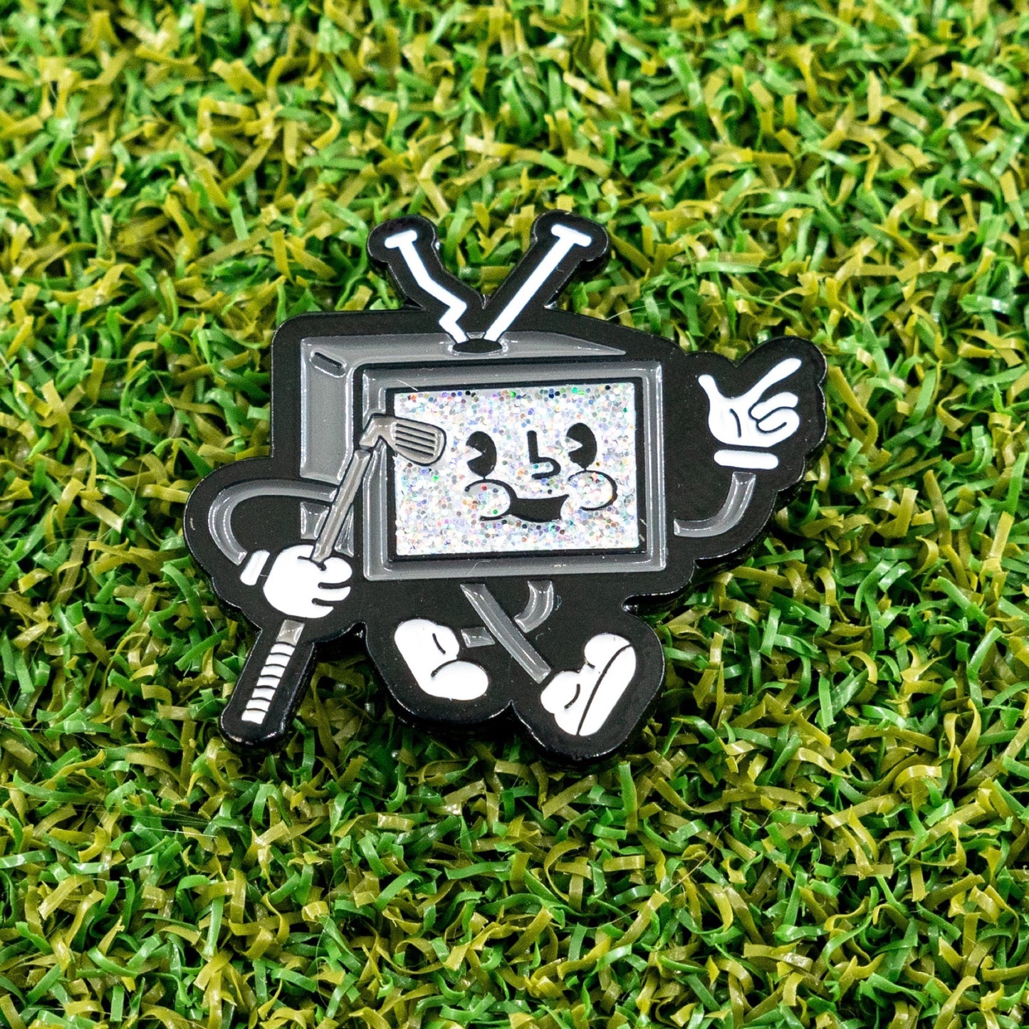 Static retro tv golf ball marker laying on a putting green