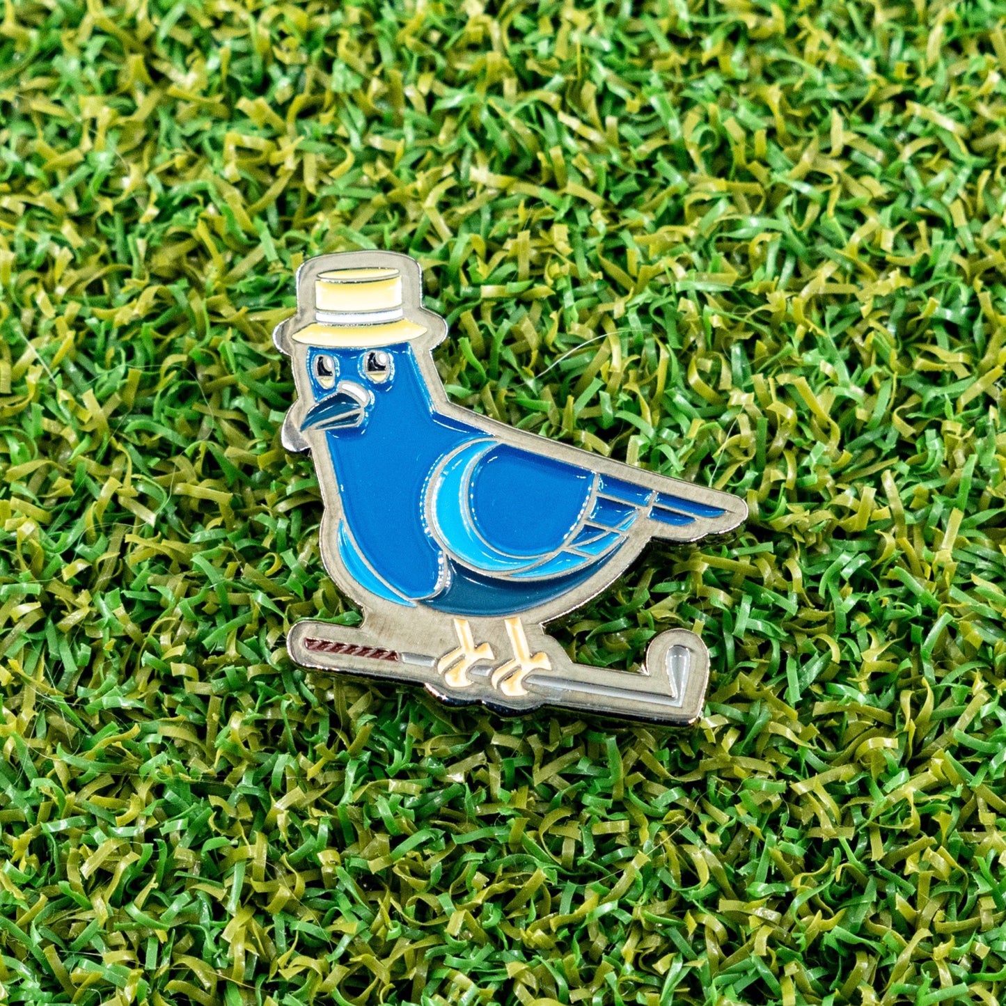 dirty birdie golf ball marker laying on a putting green.